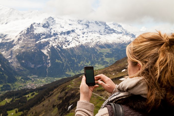 una niña disparando una imagen de paisaje en un teléfono inteligente