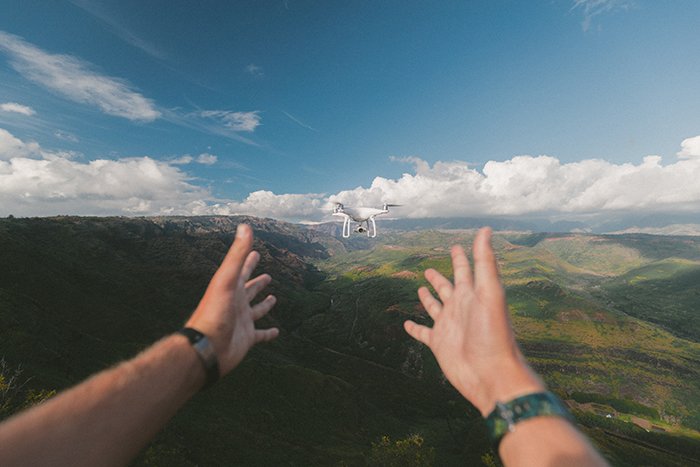 Una foto de manos soltando un dron volador