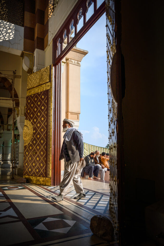 El hombre pasa frente a las puertas adornadas para entrar al santuario