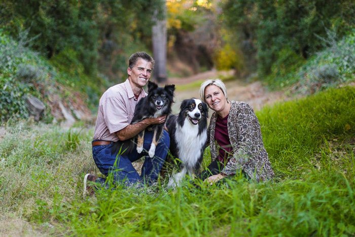 una pareja con dos perros posando para una sesión de fotos