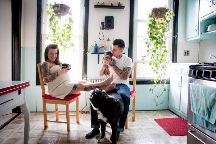 Foto de una pareja con 2 perros relajándose en la cocina por Nina Robinson