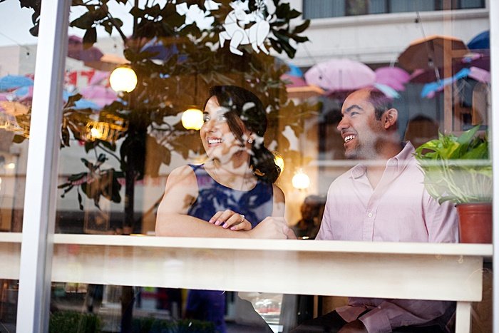 una pareja sonriendo en la ventana de un café