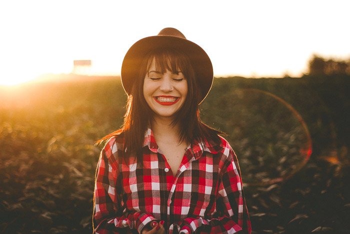 Foto de retrato de una modelo femenina con sombrero negro tomada en la hora dorada