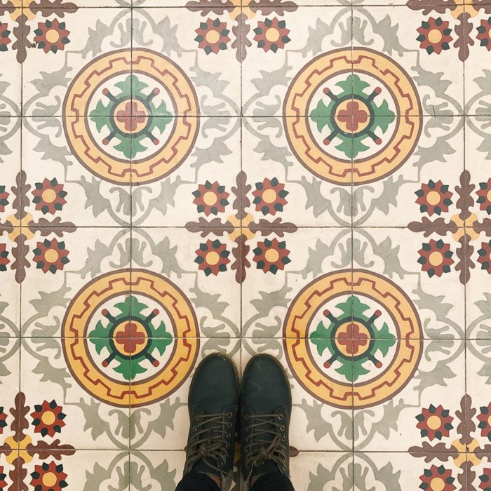 Fotografía aérea de un piso estampado y los pies de los fotógrafos procesados ​​con VSCO con el ajuste preestablecido c3.  Consejos de Instagram para fotografía de redes sociales.