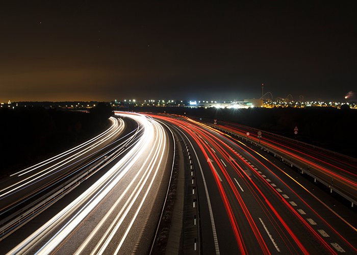 Fotografía nocturna de larga exposición con semáforos en la carretera