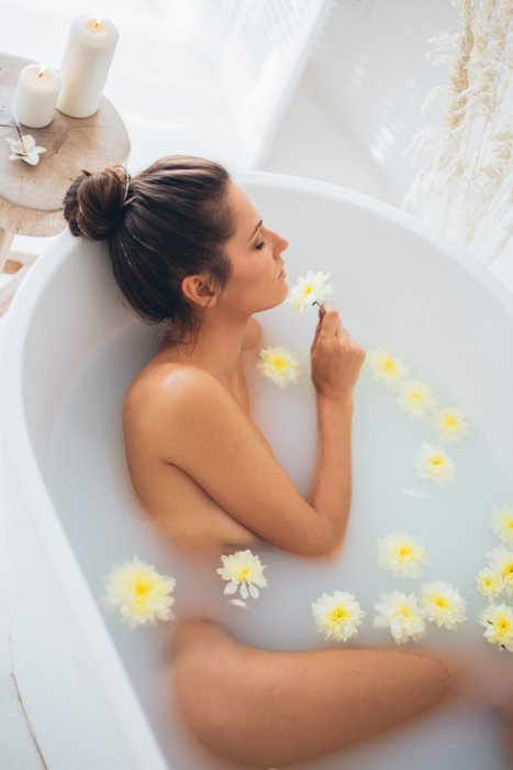 Una sesión íntima de baño de leche con flores.