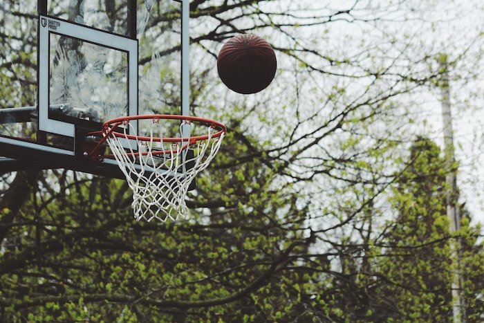 Una pelota de baloncesto lanzada a una red - consejos de fotografía deportiva