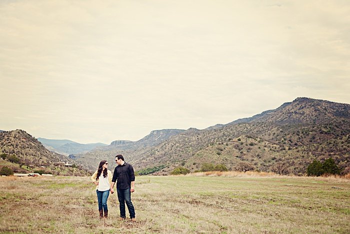 un retrato romántico de una pareja probando poses de fotos de compromiso en un paisaje pintoresco