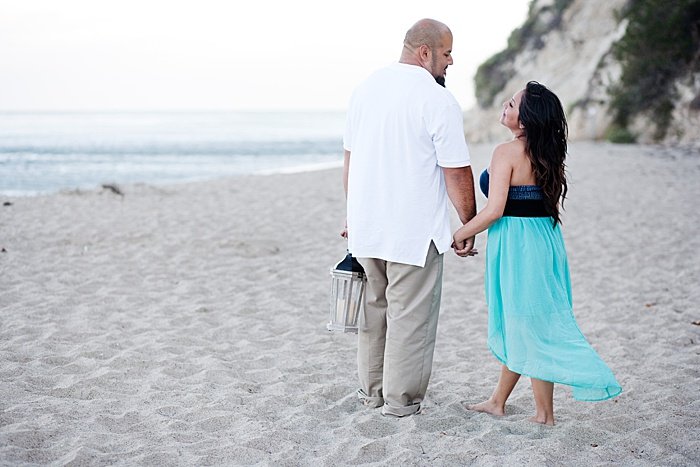 Retrato romántico de una pareja intentando poses de fotos de compromiso en la playa