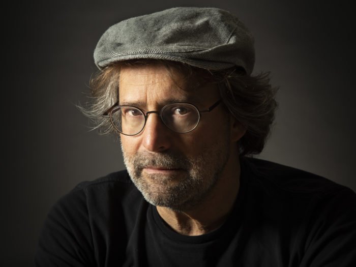 Un retrato de estudio de un hombre con sombrero y gafas