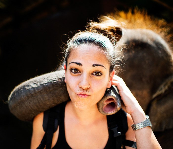 Una chica posando para un selfie con un elefante