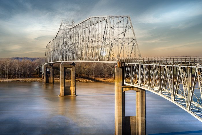 una imagen de un reemplazo del cielo sobre un puente que cruza un río