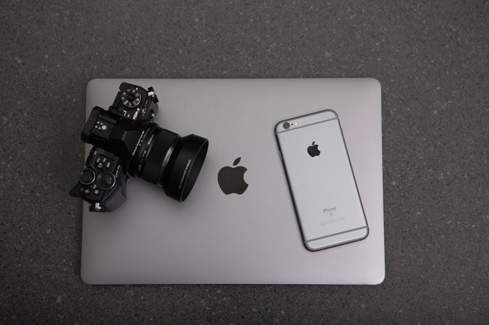 Una cámara DSLR, un iPhone y una computadora portátil