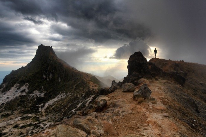 Fotografía de paisaje de un paisaje montañoso bajo cielos tormentosos: lista de verificación de fotografía de viajes.