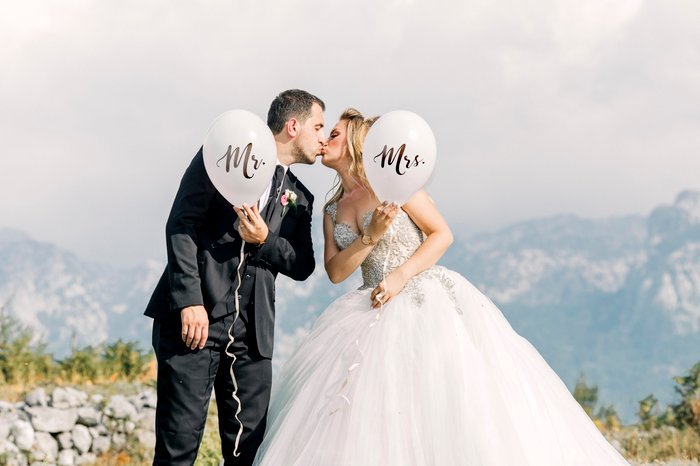 Lindo retrato de boda de la novia y el novio posando con globos