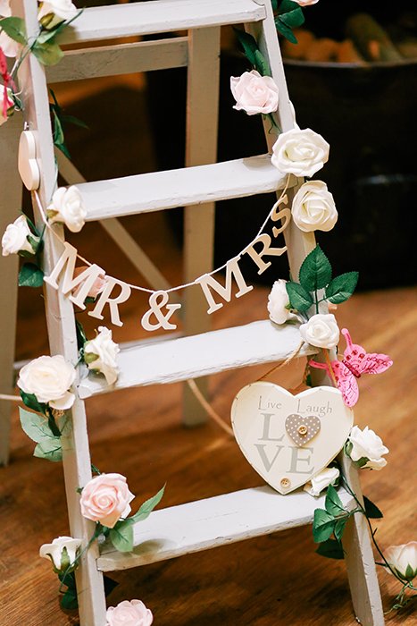 una escalera decorada con flores y letras como accesorios de fotografía de bodas