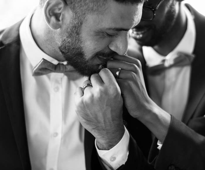 Pareja del mismo sexo dando un beso a sus manos