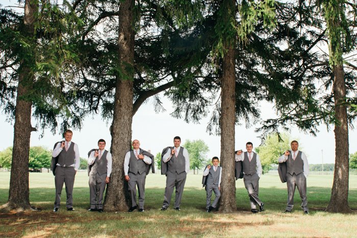 retrato de boda de los padrinos de boda posando entre árboles - consejos de negocios de fotografía de bodas