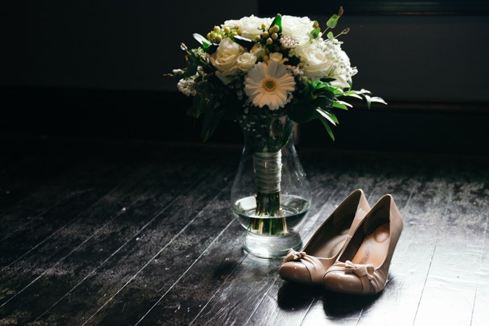 naturaleza muerta atmosférica de zapatos y flores de boda - consejos de negocios de fotografía de bodas