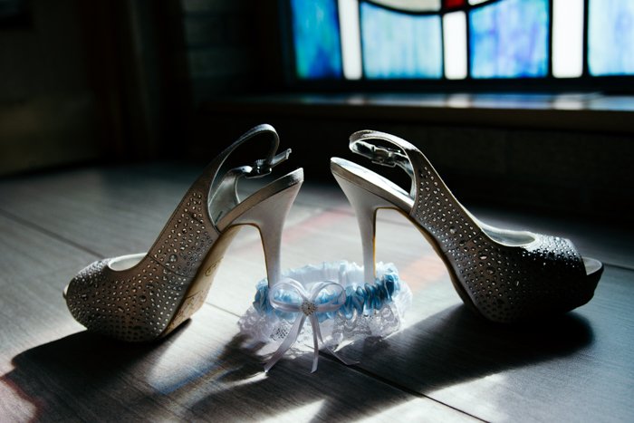 naturaleza muerta atmosférica de zapatos de boda y liga en el suelo - consejos de negocios de fotografía de bodas