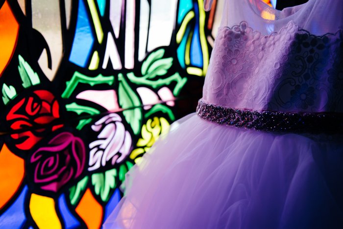 Retrato de boda de un vestido morado de damas de honor frente a vidrieras - consejos de negocios de fotografía de bodas